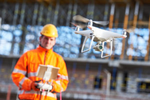 Contractor flying a drone on a construction site | How drones can help with mechanics liens