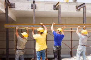 Construction workers carrying beam | In Construction Transparency is Key to Getting Paid