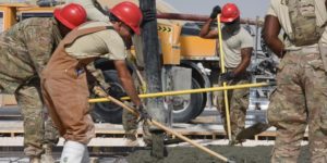Contractors lay cement on Air Force base construction project in Qatar.