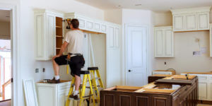 Contractor installing kitchen cabinets for a homeowner