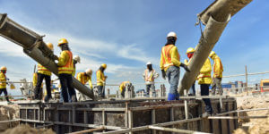 Group of contractors pouring conrete on construction site