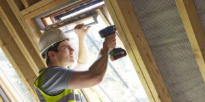 Contractor installs window during home construction project
