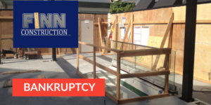 Construction site with Finn Construction logo and bankruptcy alert in red