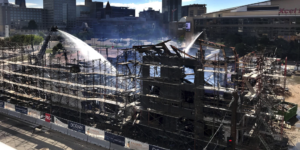 Photo of the burned St. Paul hotel site being sprayed by fire hoses