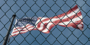 US flag flying behind a chain link fence