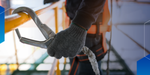 OSHA Violations – Close-up photo of worker holding clip for safety harness
