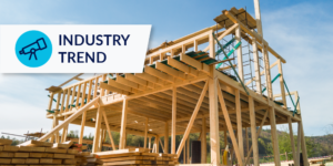 Photo of wooden structure and lumber piles at a worksite with industry trend label in the upper left corner