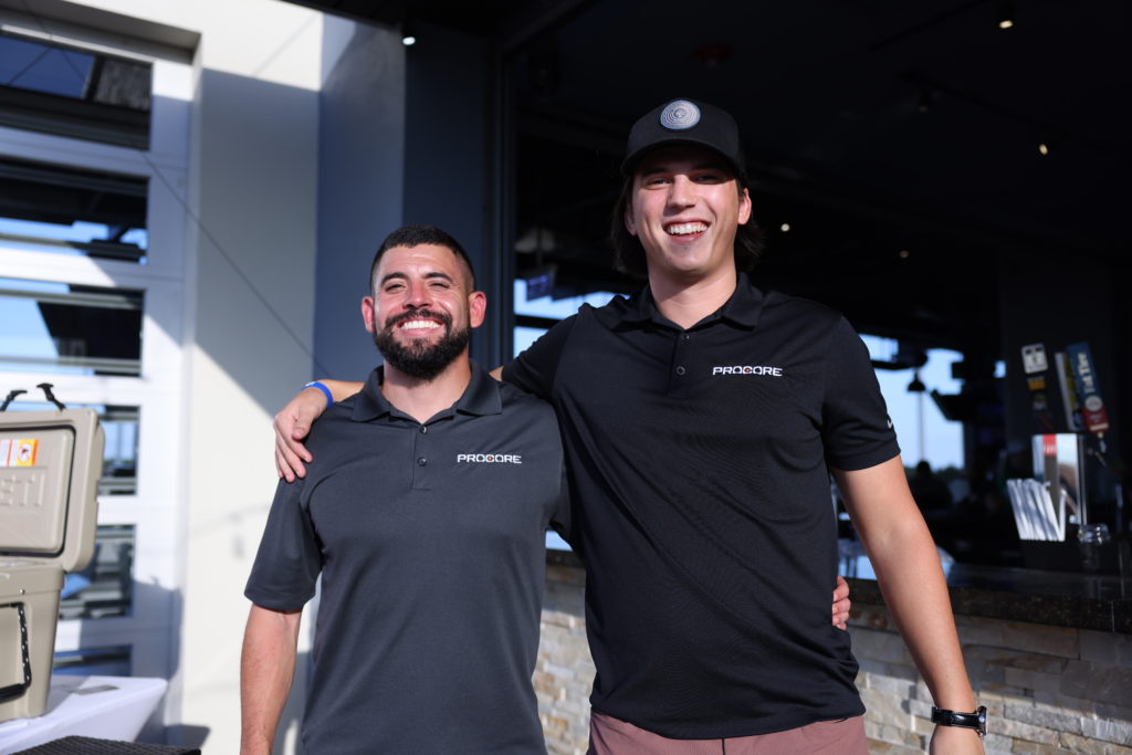 Two Procore employees smile at the camera.