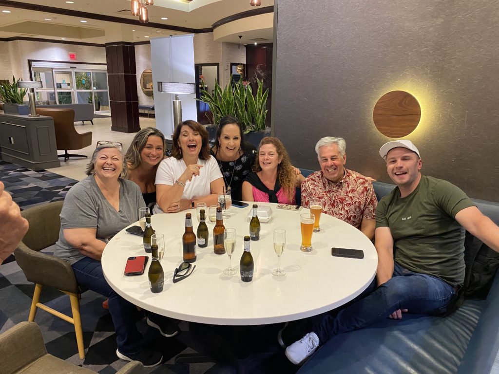 A group photo of Tampa Credit Summit attendees around a table. Pictured from left are Kathleen Quill w/HighRadius, Erin Van Doormalen w/CreditSafe, Thea Dudley, Lori J. Drake w/Levelset, Elaine Nowak w/Auditoria, and Craig Webb w/Webb Analytics