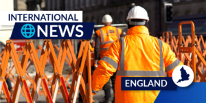 Photo of workers in orange jumpsuits and hardhats crossing into a fenced-off barrier. There is an international news label and England label