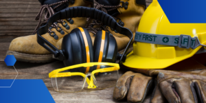Safety and health hazard construction equipment closeup photo containing earmuffs, protective glasses, workboots, gloves, and hardhat