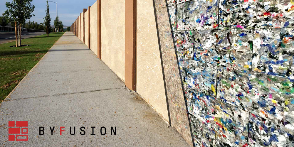 Photo of an outdoor wall with a section made of colorful ByBlocks. The ByFusion logo is in the lower left corner.