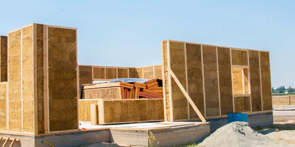 Photo of unfinished walls constructed out of straw bales.