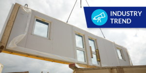 Photo of modular home wall being put into place by crane with "Industry Trend" label